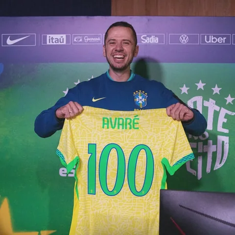 Thiago Avaré segurando a camisa da Seleção com seu nome e o número 100